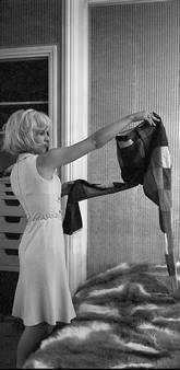 Sylvie Vartan essaye des vêtements dans sa chambre d'hôtel, 1964